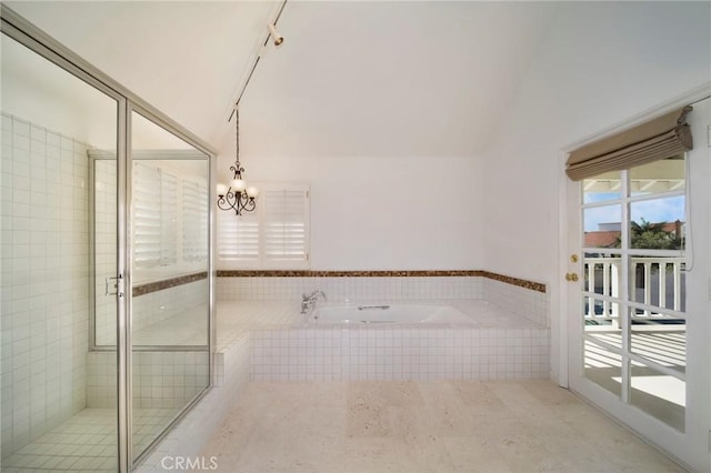 bathroom with a bath, a stall shower, an inviting chandelier, and vaulted ceiling