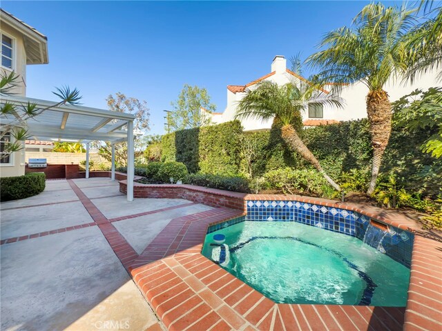 view of pool featuring an in ground hot tub and a patio