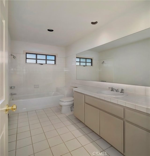 full bathroom with tiled shower / bath combo, vanity, toilet, and tile patterned flooring