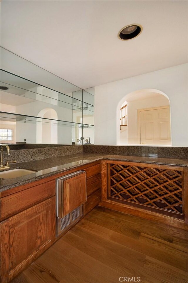 wine room featuring dark wood-type flooring and sink