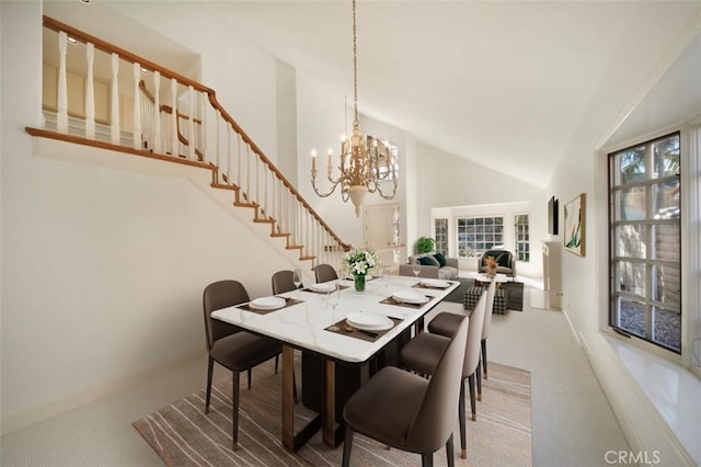 carpeted dining area with baseboards, high vaulted ceiling, an inviting chandelier, and stairs