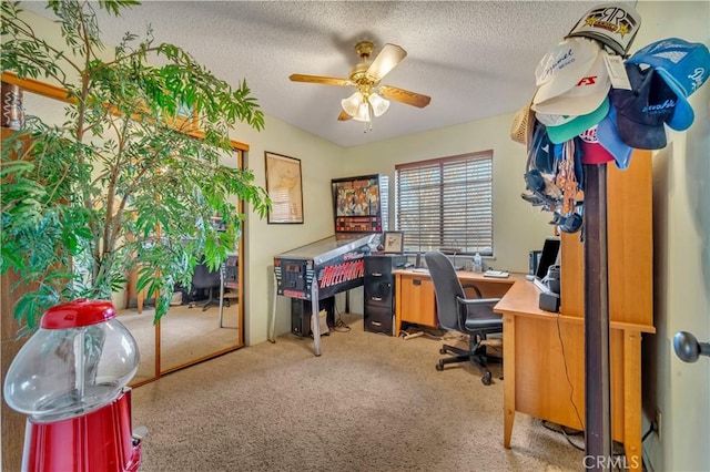 carpeted office space with a textured ceiling and ceiling fan