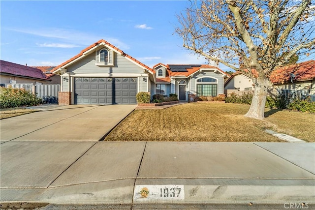 view of front of house featuring a front lawn, solar panels, and a garage