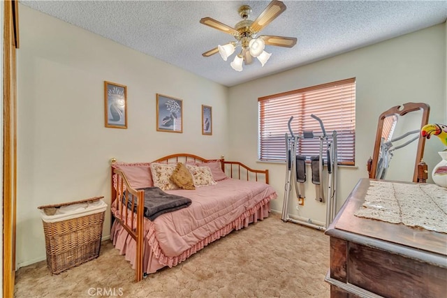 carpeted bedroom with ceiling fan and a textured ceiling