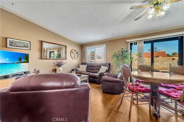 living room featuring hardwood / wood-style flooring, a textured ceiling, crown molding, and ceiling fan