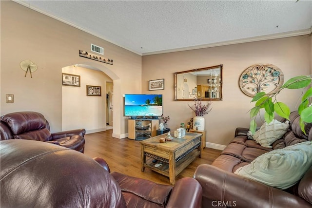 living room featuring dark hardwood / wood-style flooring, a textured ceiling, and ornamental molding