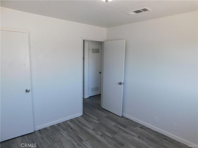 unfurnished bedroom with dark hardwood / wood-style flooring