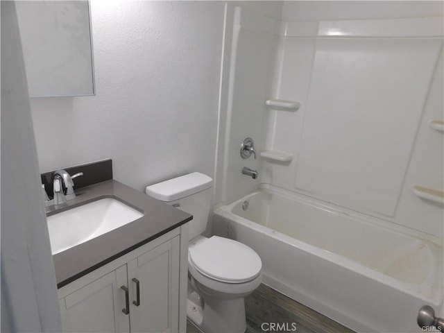 full bathroom with toilet, vanity,  shower combination, and hardwood / wood-style floors