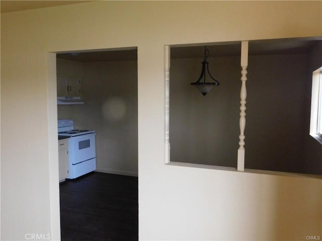 kitchen featuring dark wood-type flooring, white electric range oven, and decorative light fixtures