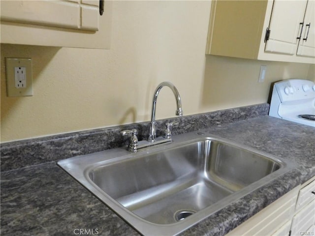 details with white cabinets, electric range, sink, and dark stone countertops