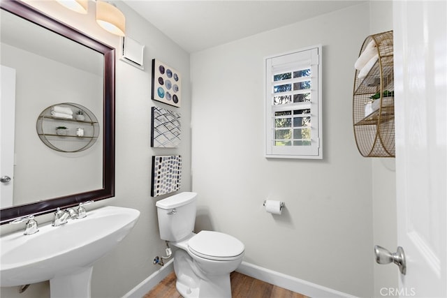 bathroom with toilet, hardwood / wood-style flooring, and sink