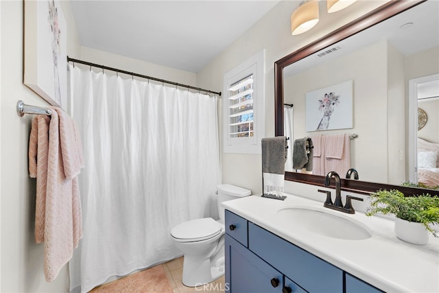 bathroom featuring toilet, vanity, and tile patterned flooring