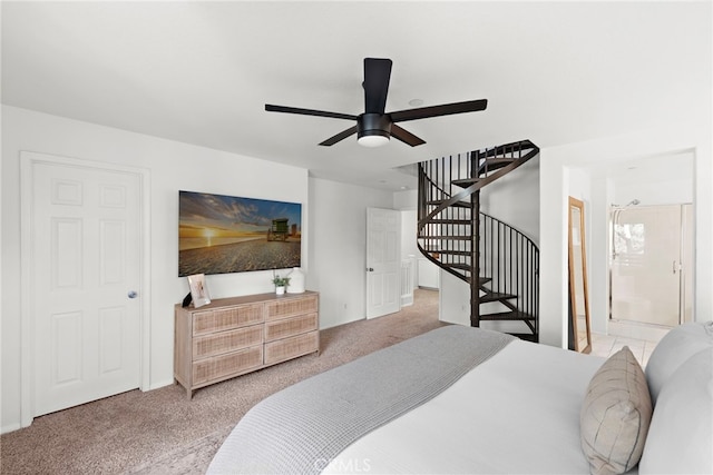 carpeted bedroom with ensuite bathroom and ceiling fan