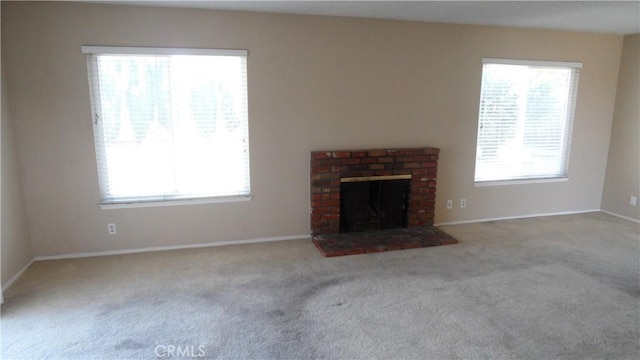 unfurnished living room featuring a fireplace, a wealth of natural light, and light colored carpet