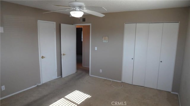 unfurnished bedroom featuring ceiling fan, light colored carpet, and a closet