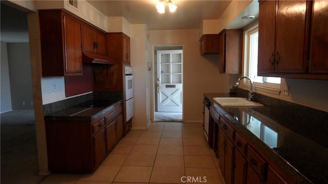 kitchen featuring light tile patterned floors, dishwasher, sink, and black electric cooktop