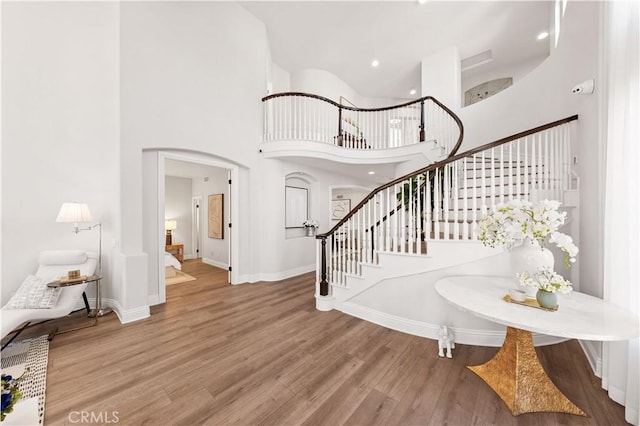 entrance foyer with wood-type flooring and a towering ceiling