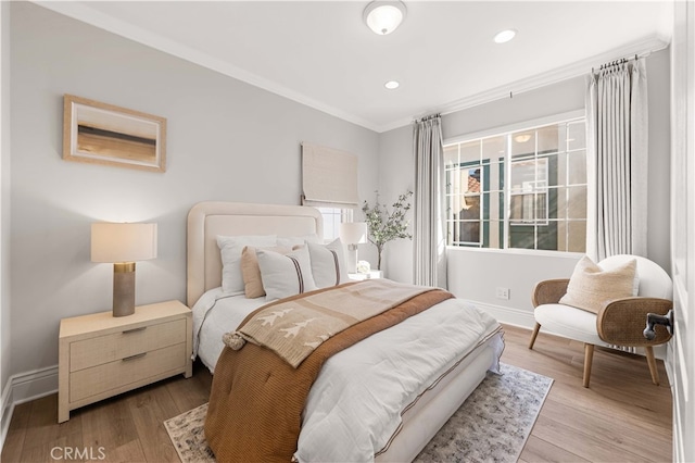 bedroom with ornamental molding and light hardwood / wood-style floors