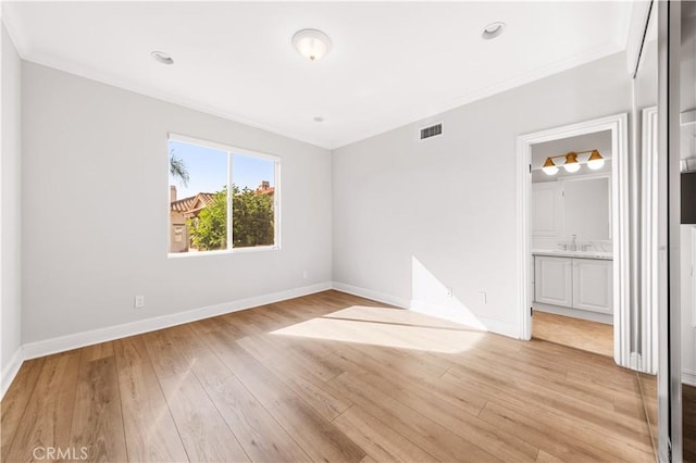 empty room featuring crown molding and light hardwood / wood-style flooring