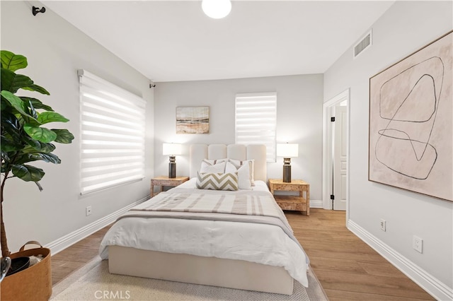 bedroom featuring light hardwood / wood-style flooring and multiple windows