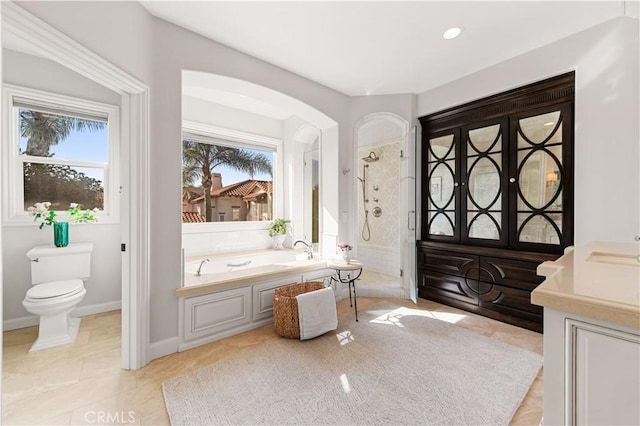 bathroom featuring toilet, a healthy amount of sunlight, tile patterned flooring, and shower with separate bathtub