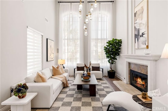 living room featuring a notable chandelier, a tile fireplace, and light hardwood / wood-style flooring