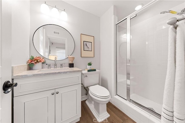 bathroom with walk in shower, vanity, toilet, and hardwood / wood-style flooring