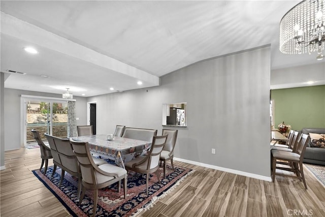 dining space featuring light wood-type flooring and an inviting chandelier