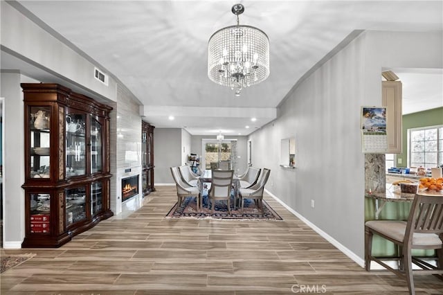 dining area with a fireplace and a chandelier