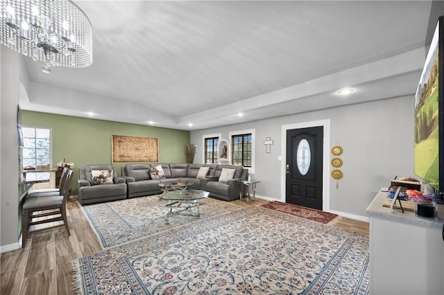 living room featuring wood-type flooring, plenty of natural light, and an inviting chandelier