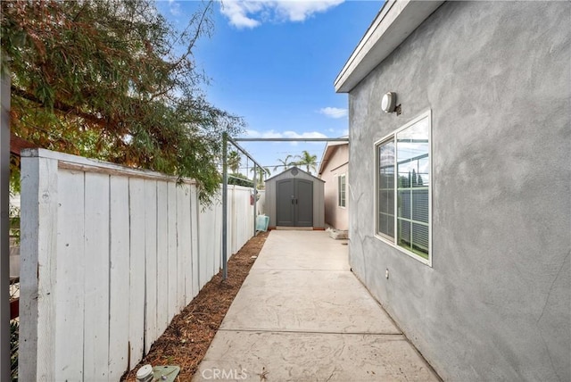 view of property exterior featuring a patio area and a storage shed