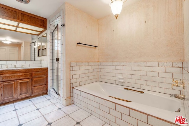 bathroom with tile patterned floors, vanity, and independent shower and bath