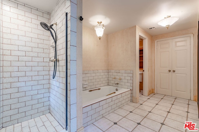 bathroom featuring toilet, tile patterned flooring, and shower with separate bathtub