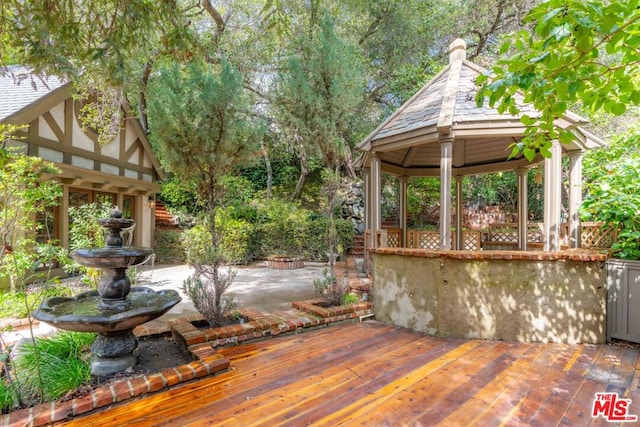 wooden terrace with a gazebo and a patio