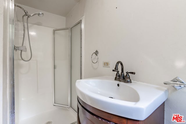 bathroom with walk in shower and vanity