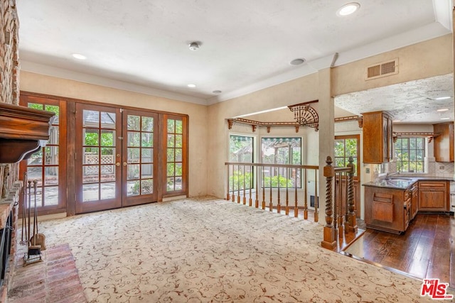 kitchen featuring dark wood-type flooring, decorative backsplash, french doors, and sink