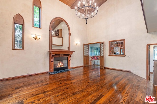 unfurnished living room with a notable chandelier, beamed ceiling, wood ceiling, high vaulted ceiling, and dark hardwood / wood-style flooring