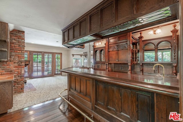 kitchen with dark hardwood / wood-style floors, dark brown cabinets, and french doors