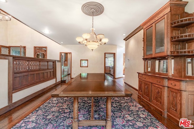 dining room featuring dark hardwood / wood-style flooring and an inviting chandelier