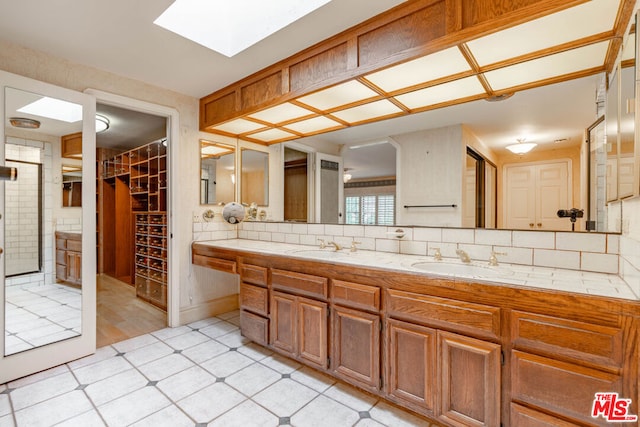 bathroom featuring vanity, a skylight, and decorative backsplash