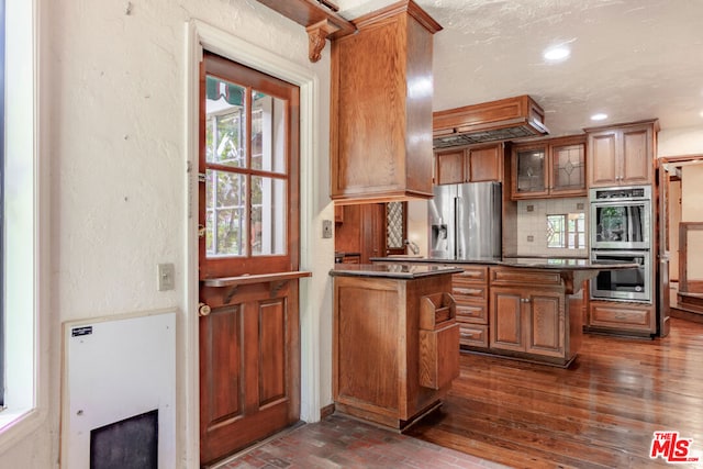 kitchen with stainless steel appliances, a healthy amount of sunlight, a kitchen bar, and backsplash