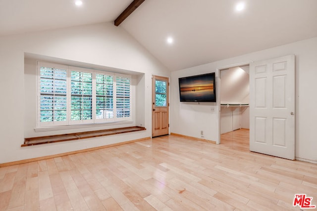 unfurnished living room with beam ceiling, high vaulted ceiling, and light hardwood / wood-style floors