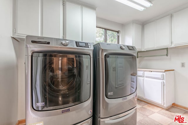 laundry area featuring washer and dryer and cabinets