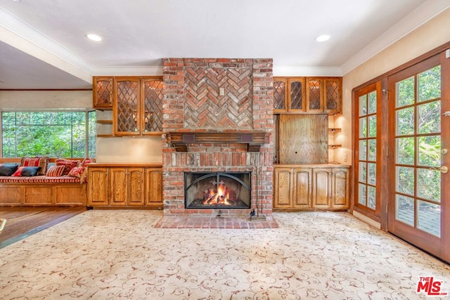 living room with a brick fireplace, crown molding, and light hardwood / wood-style flooring