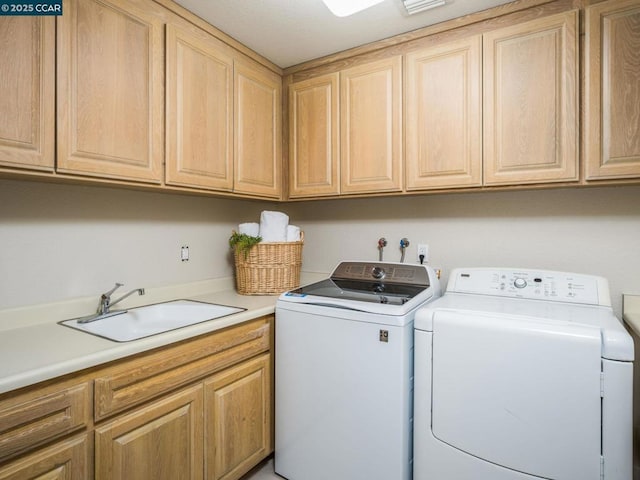 laundry room with separate washer and dryer, sink, and cabinets