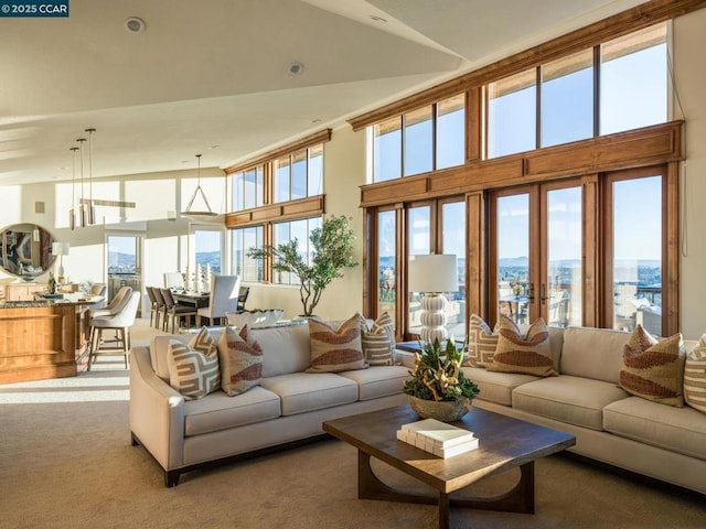 carpeted living room featuring a towering ceiling and french doors