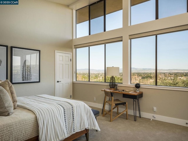 bedroom with a towering ceiling and carpet flooring