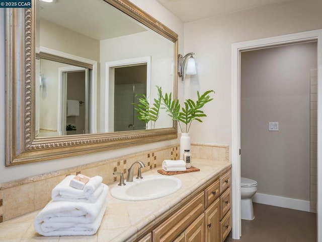 bathroom featuring vanity, backsplash, and toilet