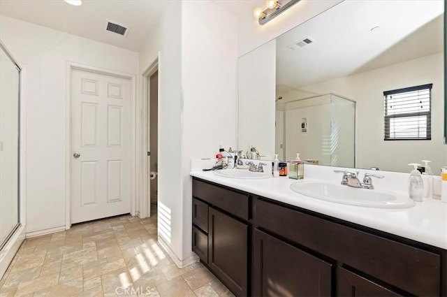 bathroom with vanity and a shower with door