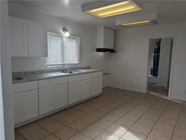 kitchen featuring light tile patterned floors, white cabinets, and sink